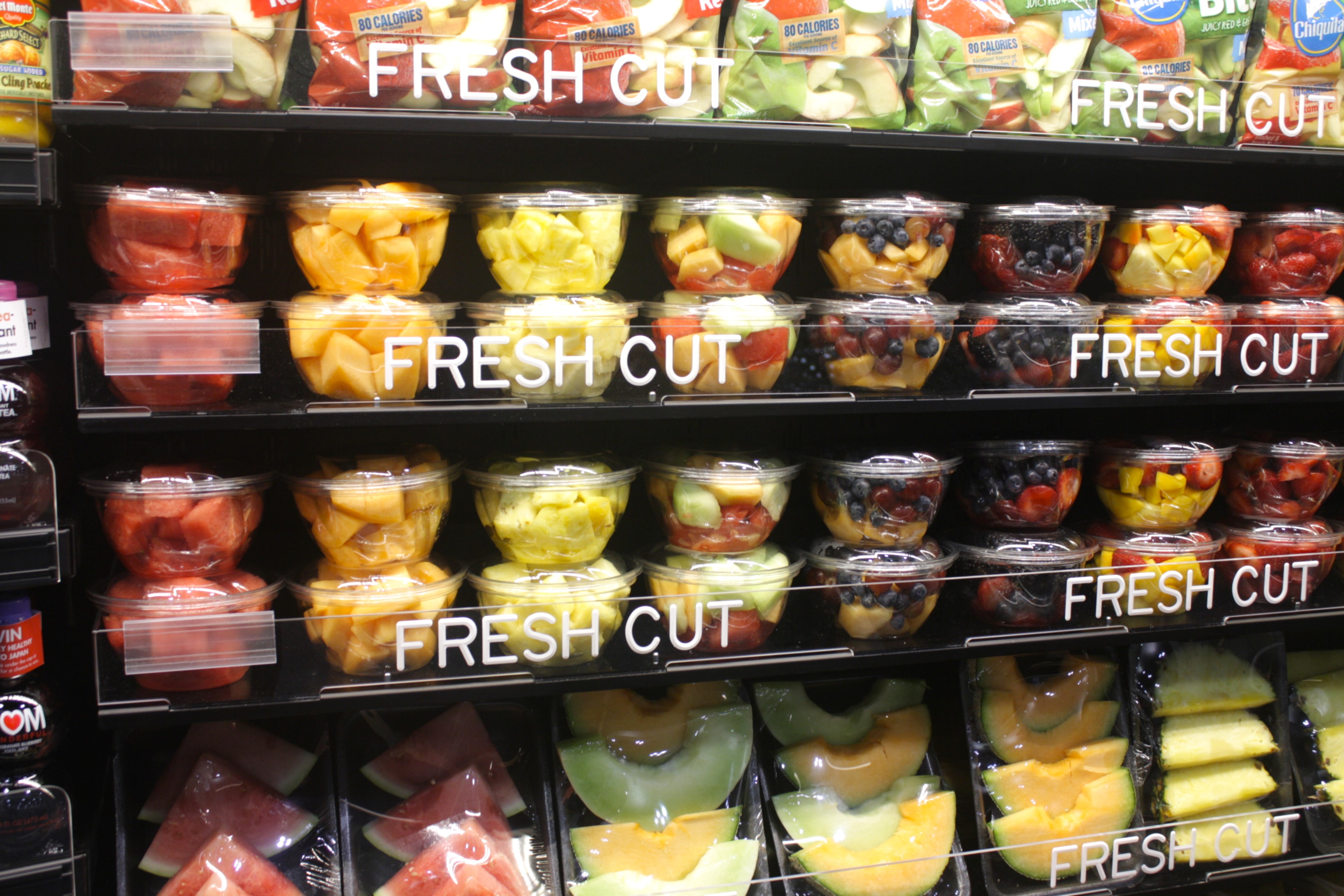 Colorful refrigerated display of fresh-cut fruit—watermelon, pineapple, grapes, berries, and melon blends—neatly arranged in clear containers on Carlson AirFlo’s AirShelf system. Designed for high visibility and airflow efficiency, this Grab-and-Go setup enhances freshness, impulse appeal, and operational ease in produce merchandising.