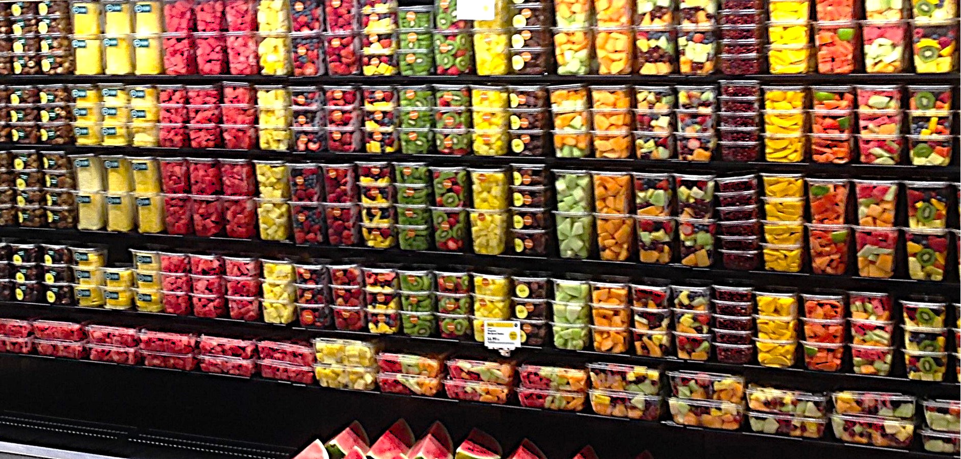 Packaged sliced fruits set upon a self layered on top of each in a sequencing color display. 