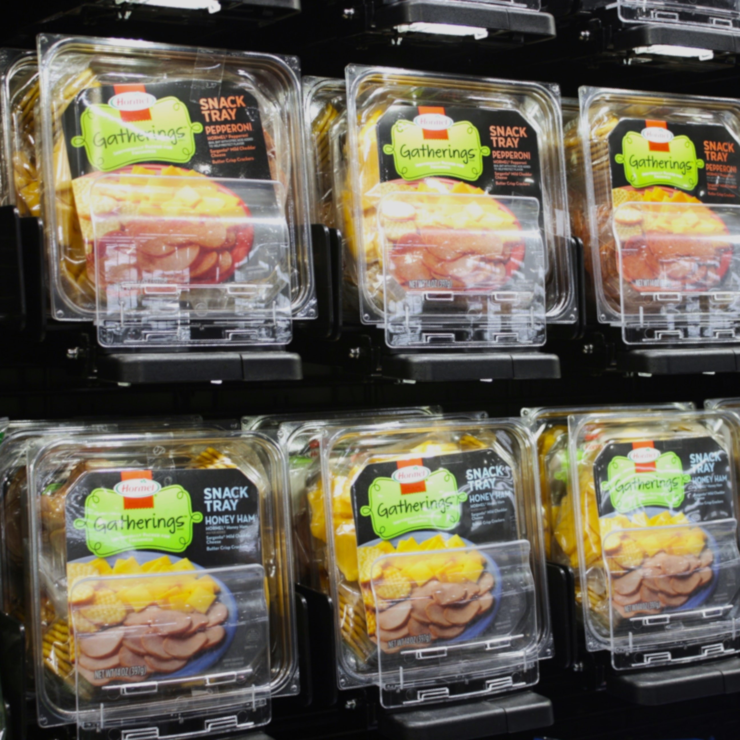 Refrigerated display of Hormel Gatherings snack trays—featuring pepperoni, salami, and honey ham varieties—neatly organized with Carlson AirFlo’s ELITE Self Facer for a premium Grab-and-Go experience. Clear packaging and front-facing alignment enhance visibility, convenience, and impulse appeal in high-traffic retail zones.