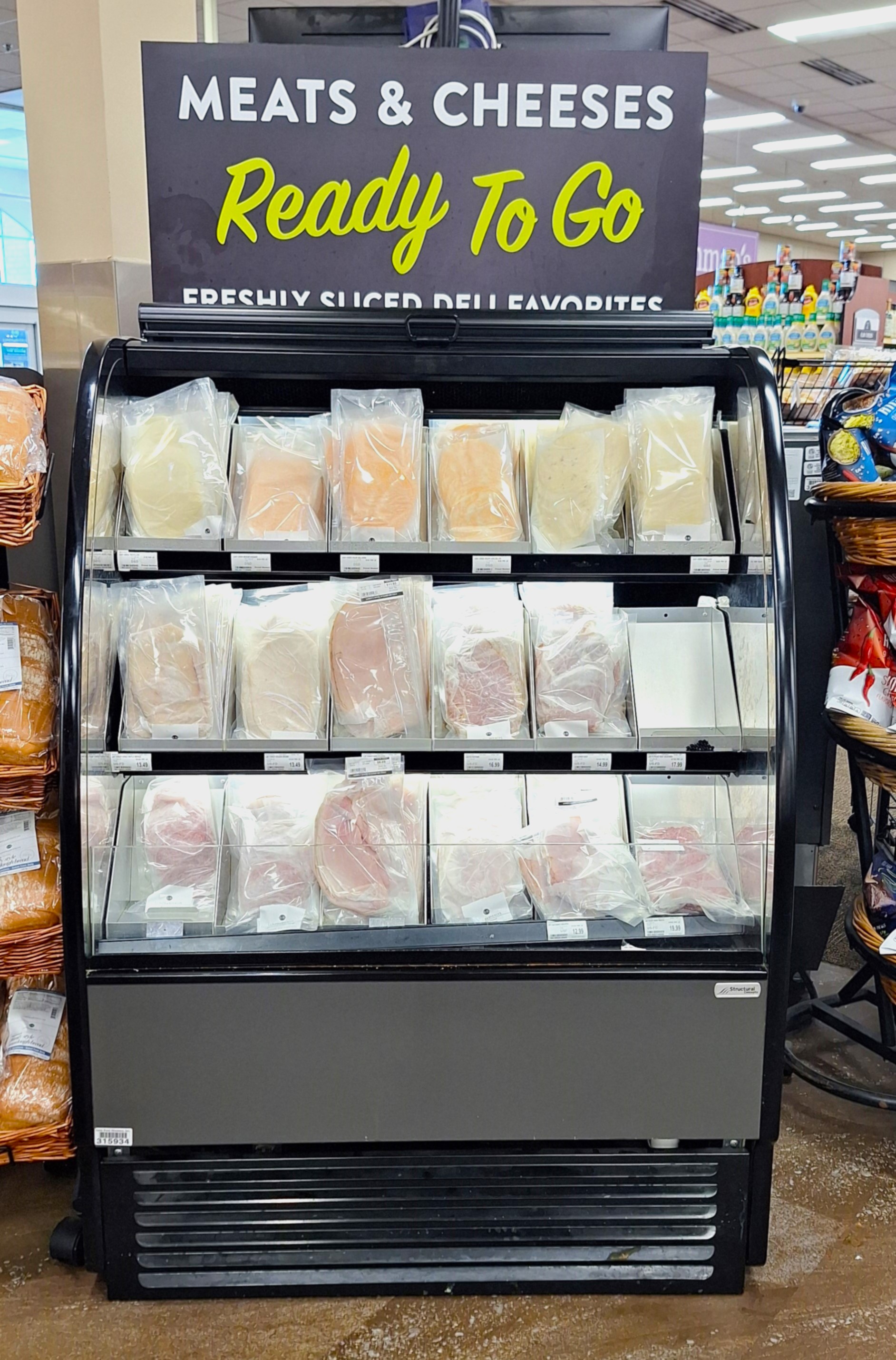 Refrigerated Delibox display showcasing vacuum-sealed sliced meats and cheeses under a bold “Meats & Cheeses Ready To Go” sign, organized with Carlson AirFlo’s precision-engineered system for optimal Grab-and-Go convenience. Clean lines, clear labeling, and tiered shelving enhance product visibility and shopper efficiency in deli merchandising.