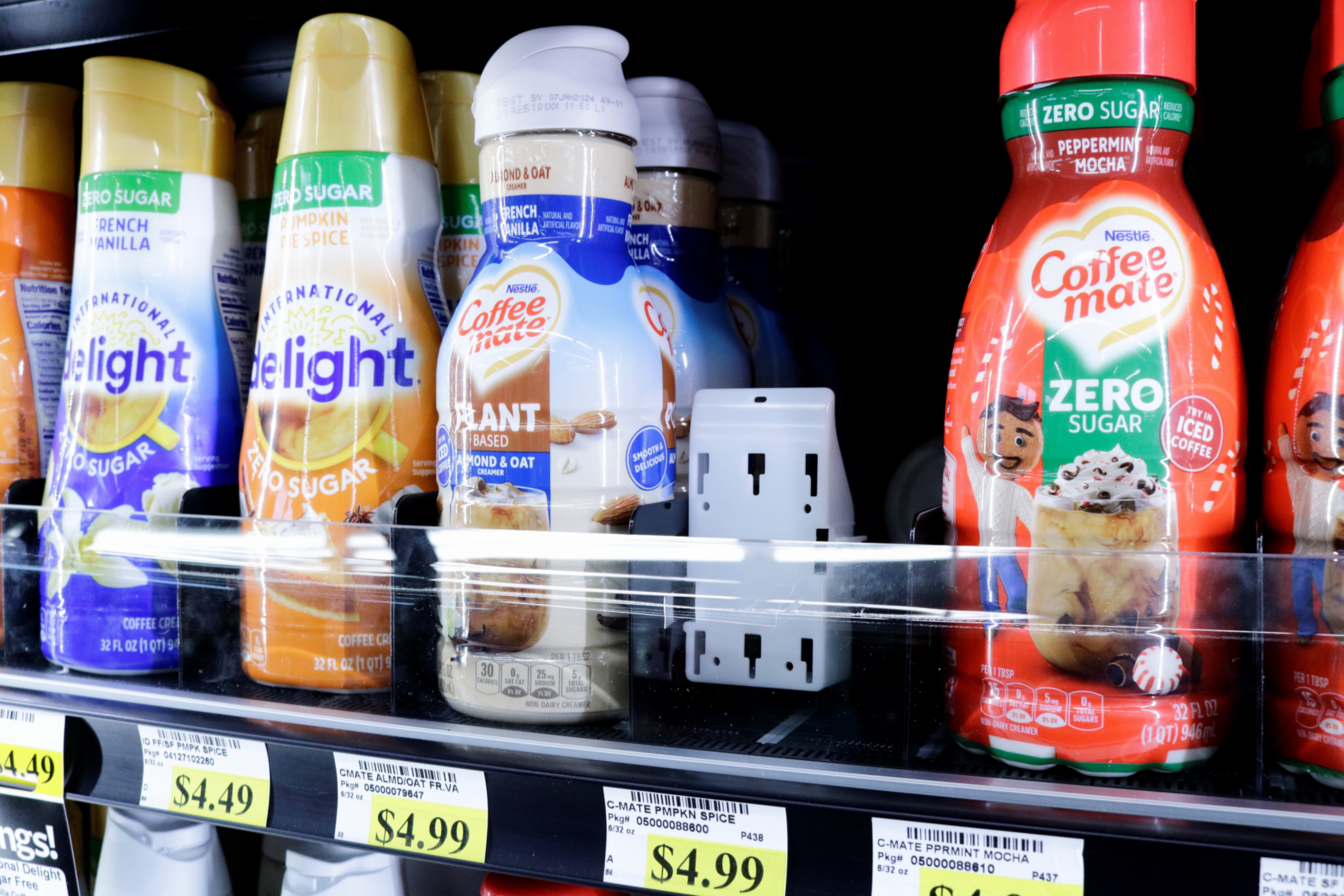 Refrigerated shelf featuring a vibrant selection of Coffee mate and Delight creamers, including zero sugar and oatmilk options, organized in a clean, accessible Grab-and-Go display powered by Carlson AirFlo’s merchandising systems. Product includes AirFlos pusher system.